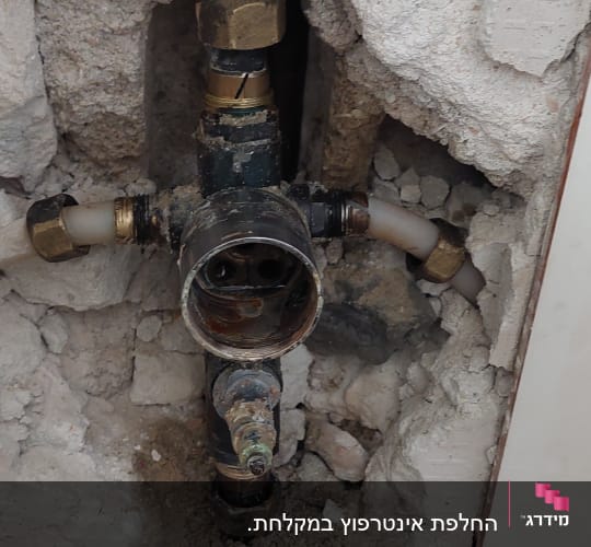 צנרת חשופה בקיר עם חיבורים ומחברים